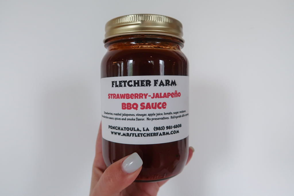 8oz jar of local Mrs. Fletcher Farms Strawberry Jalapeño BBQ Sauce from Fletcher Farms. This spicy-sweet BBQ sauce is made with local Ponchatoula strawberries and fresh jalapeños.